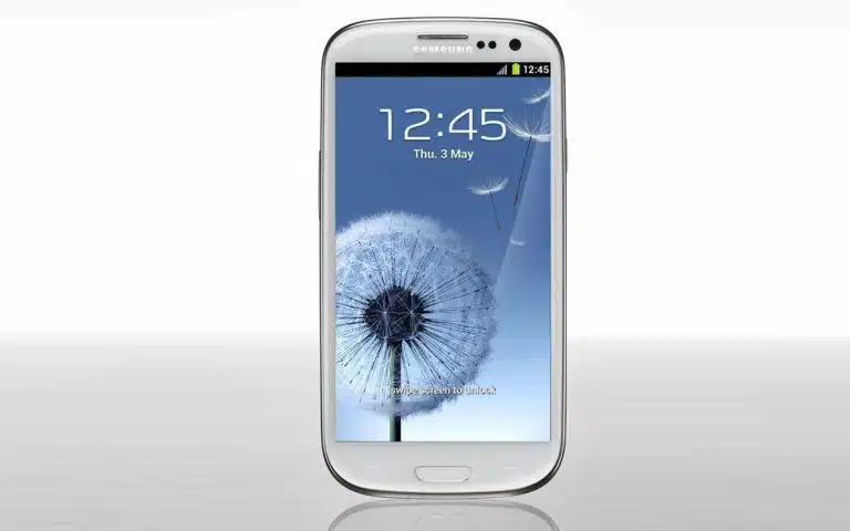 un gros plan d'un téléphone portable avec un pissenlit en arrière-plan