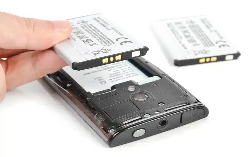 quelqu'un tient un téléphone portable avec une batterie attachée à celui-ci