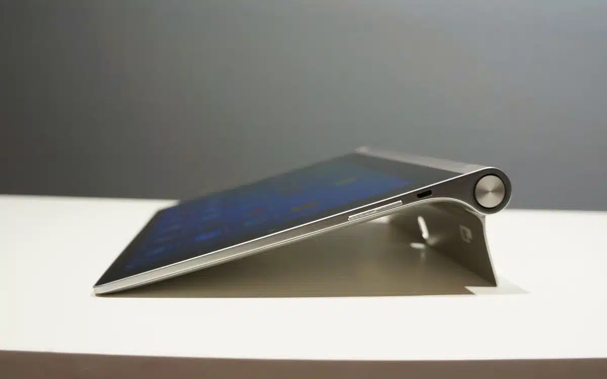 il y a un ordinateur tablette assis sur une table avec un support métallique