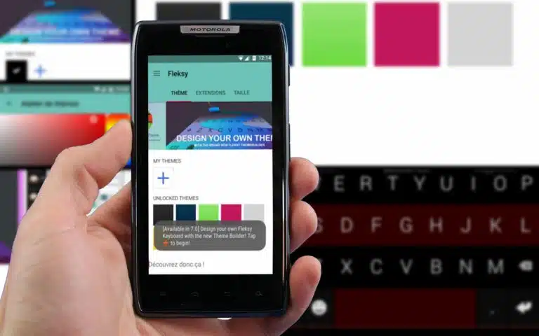 quelqu'un tenant un téléphone intelligent dans sa main avec un clavier en arrière-plan