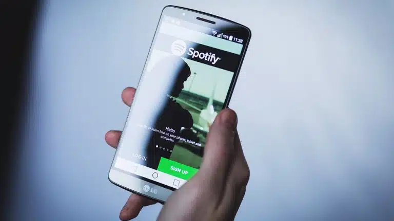 quelqu'un tient un téléphone intelligent avec une application spotify à l'écran